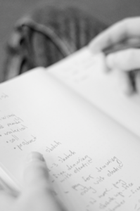 Person writing with a pen in a notebook. 